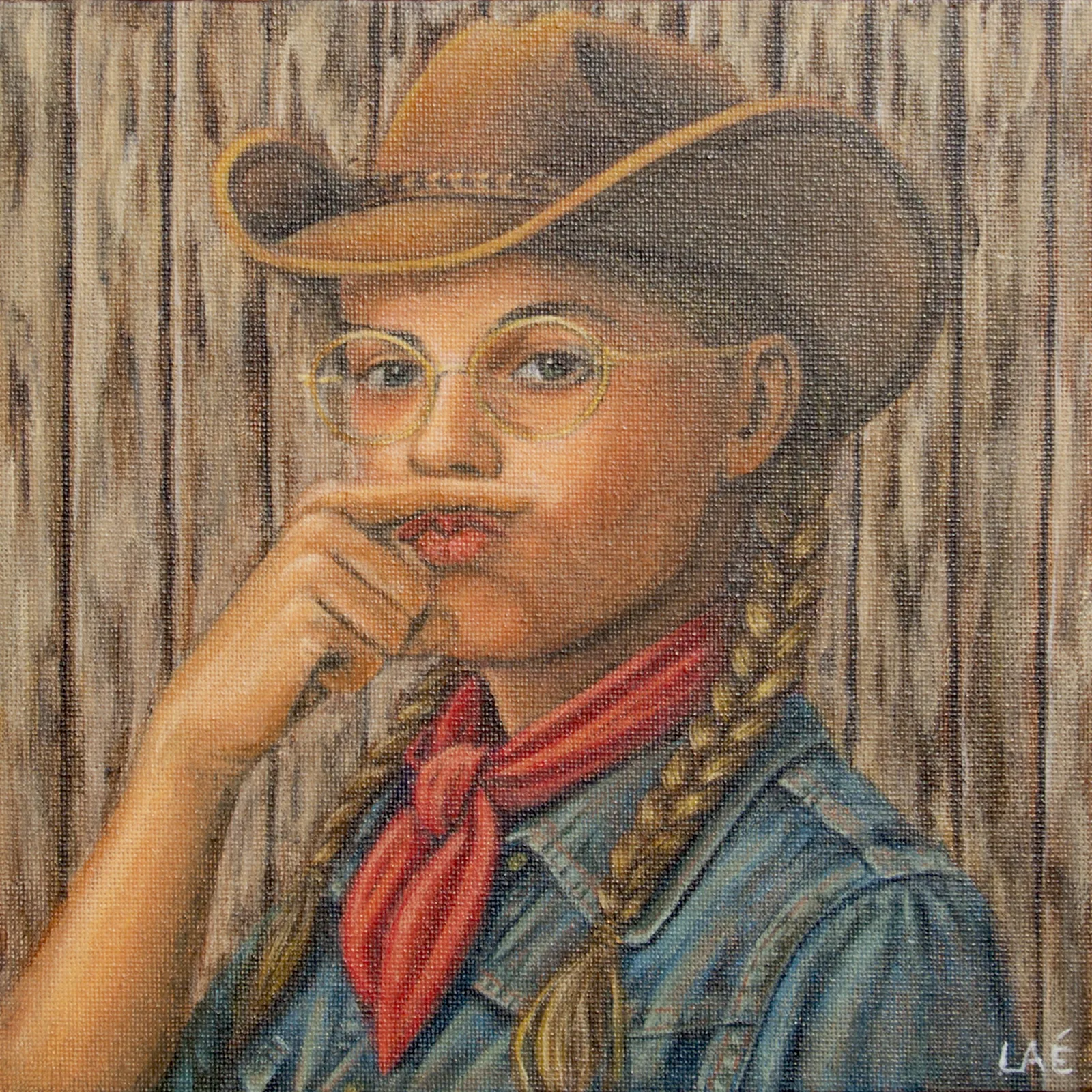 Fillette en chapeau de cowboy, nattes blondes et foulard rouge, un doigt devant la bouche, adossée à une palissade de bois.